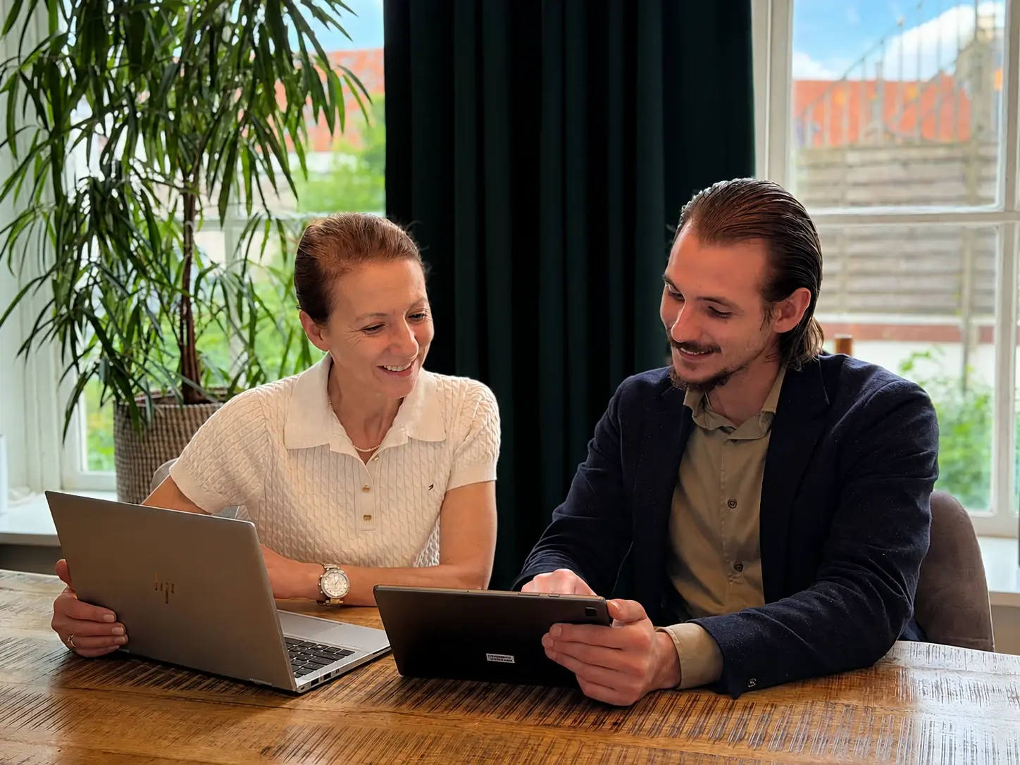 Twee collega's bekijken samen een tablet