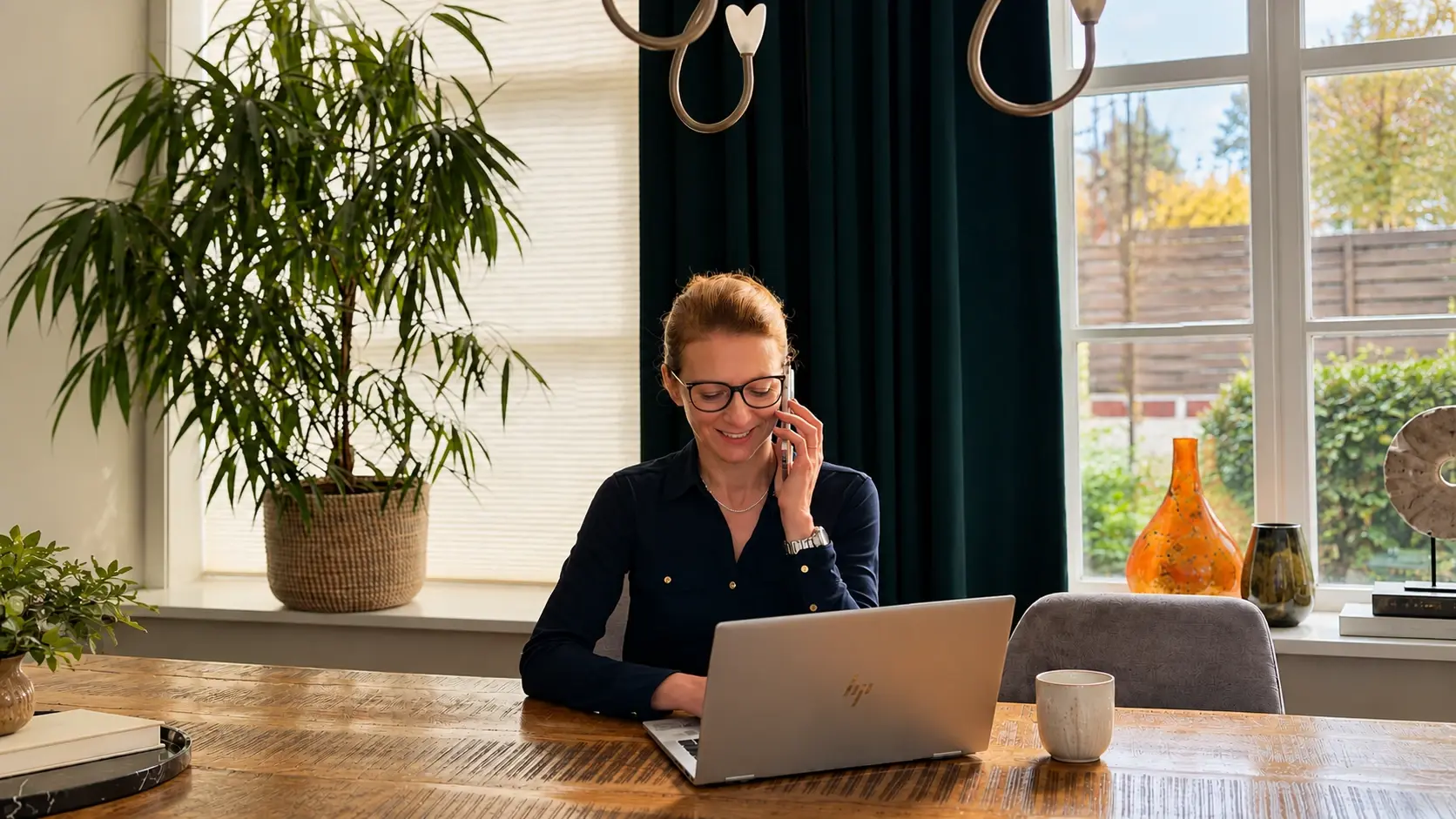 Vrouw werkt aan een laptop en belt vanaf haar bureau